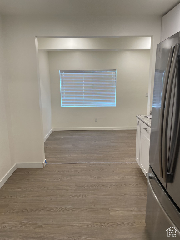 Unfurnished dining area with wood finished floors and baseboards