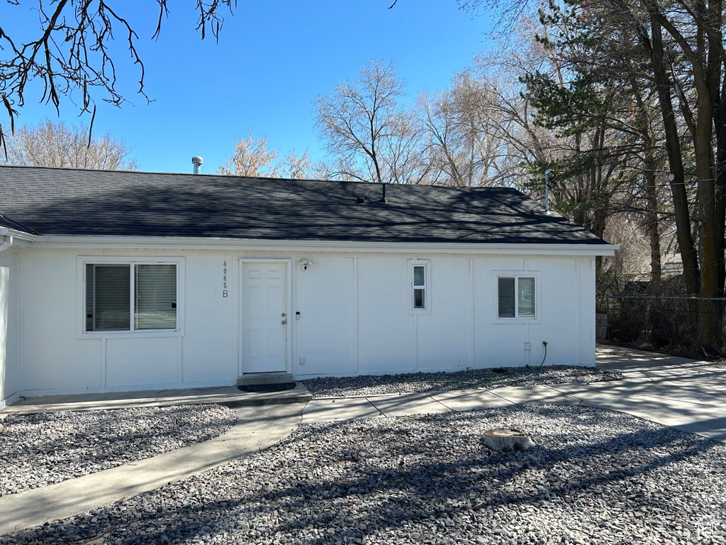 Back of house featuring a shingled roof and fence