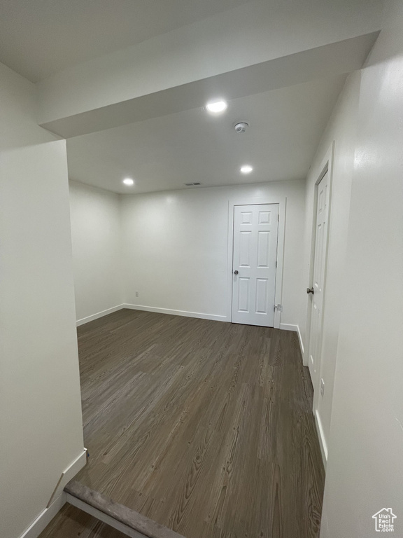 Basement featuring dark wood-style flooring, baseboards, and recessed lighting