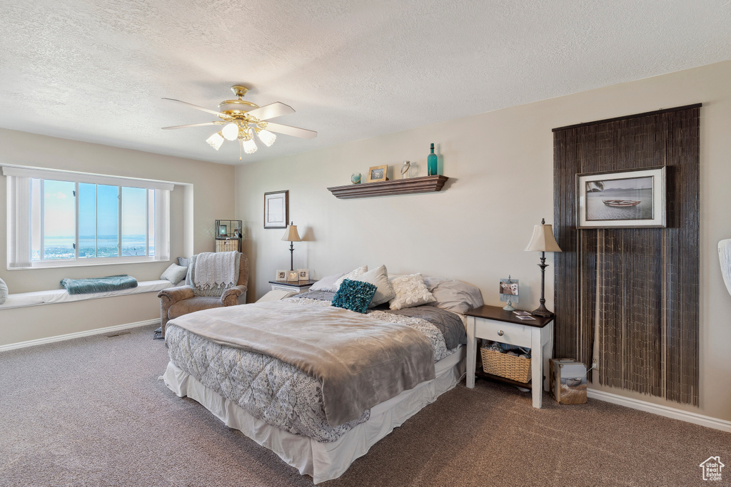 Bedroom with carpet flooring, a ceiling fan, a textured ceiling, and baseboards