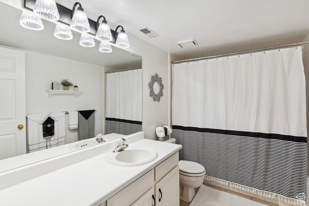 Bathroom with vanity, toilet, and visible vents