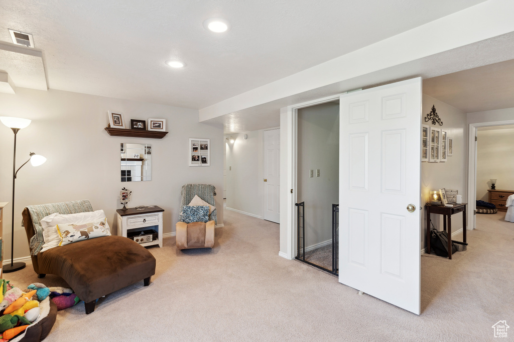 Living area with recessed lighting, baseboards, light colored carpet, and visible vents