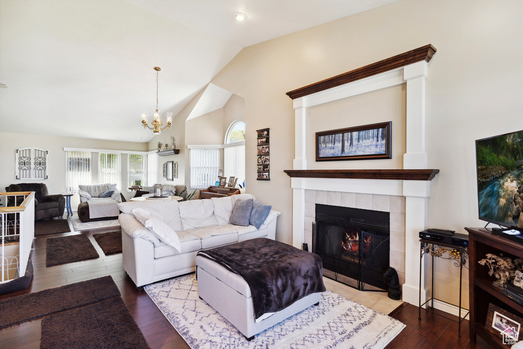 Living area featuring high vaulted ceiling, a chandelier, a healthy amount of sunlight, and a fireplace