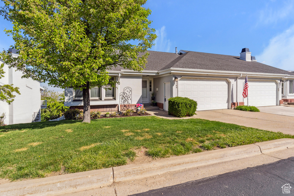 Single story home with a garage, a front lawn, concrete driveway, a shingled roof, and stucco siding
