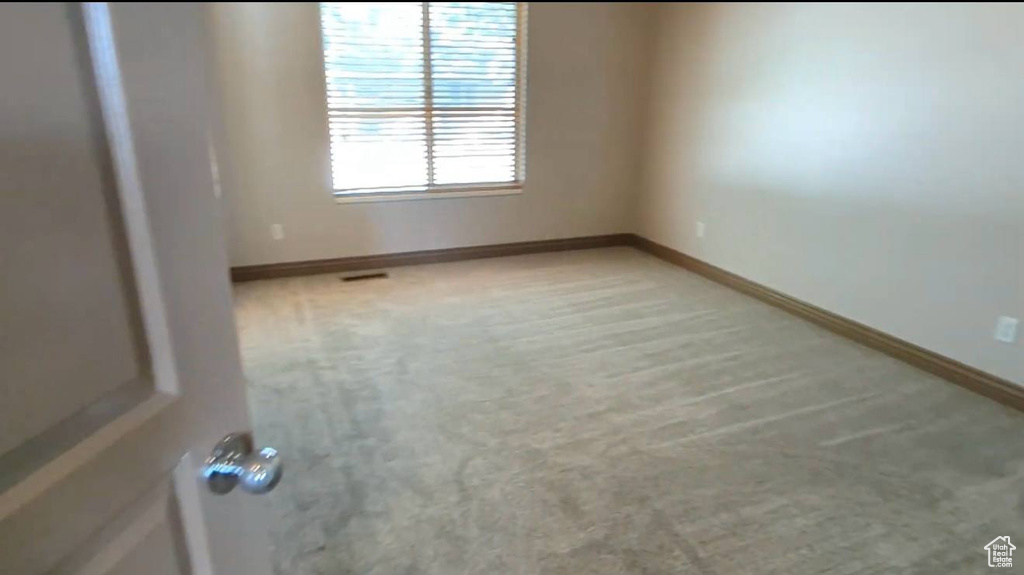 Unfurnished room with light colored carpet and baseboards