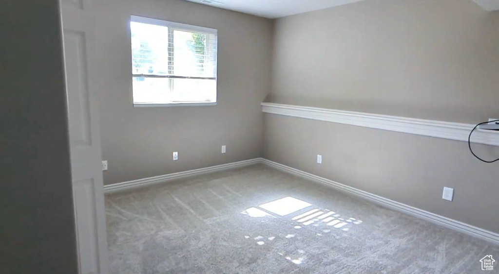 Carpeted empty room featuring baseboards