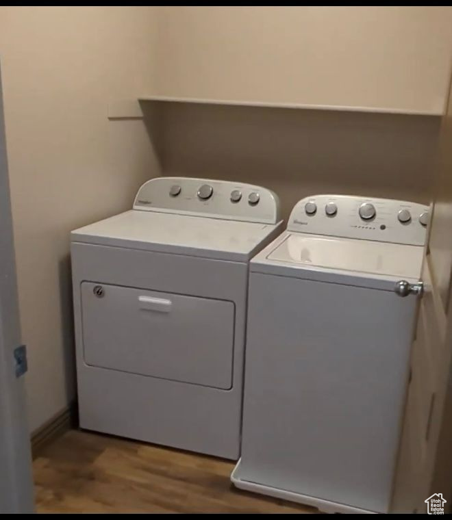 Laundry room with washing machine and clothes dryer and wood finished floors