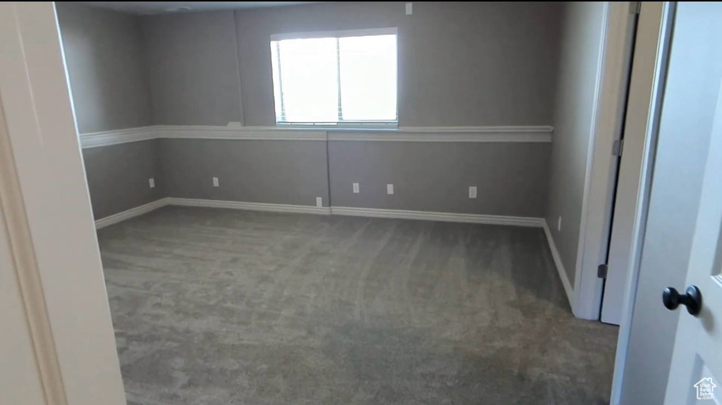 Carpeted empty room featuring baseboards