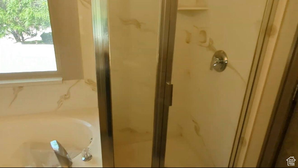 Bathroom featuring a shower stall and a bath