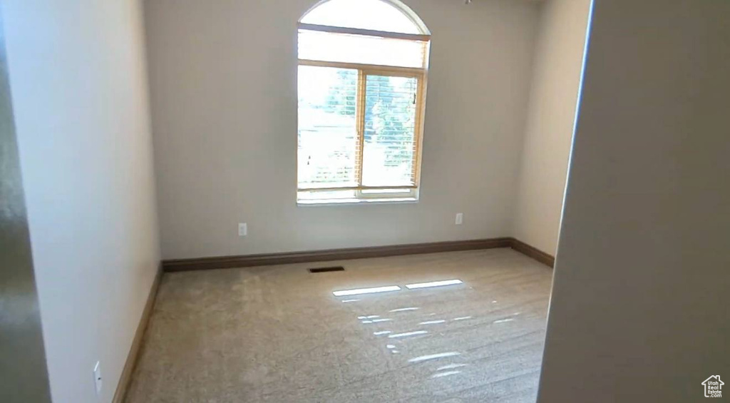 Carpeted spare room with baseboards