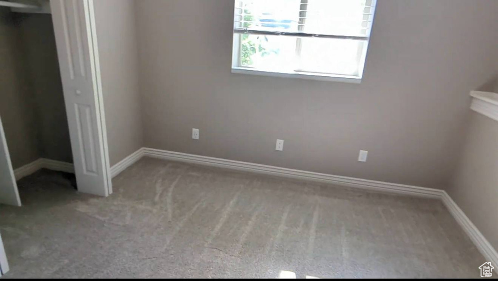 Unfurnished bedroom featuring carpet and baseboards