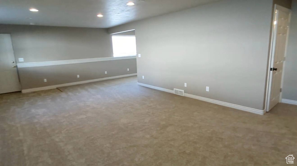 Carpeted spare room featuring baseboards and recessed lighting