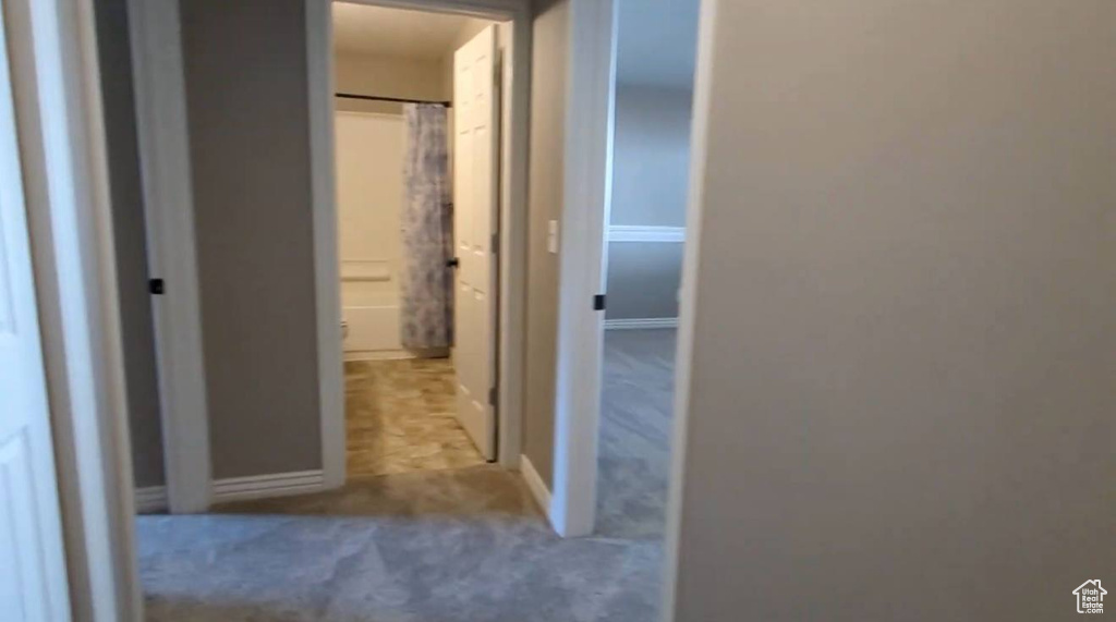 Hall featuring carpet flooring and baseboards