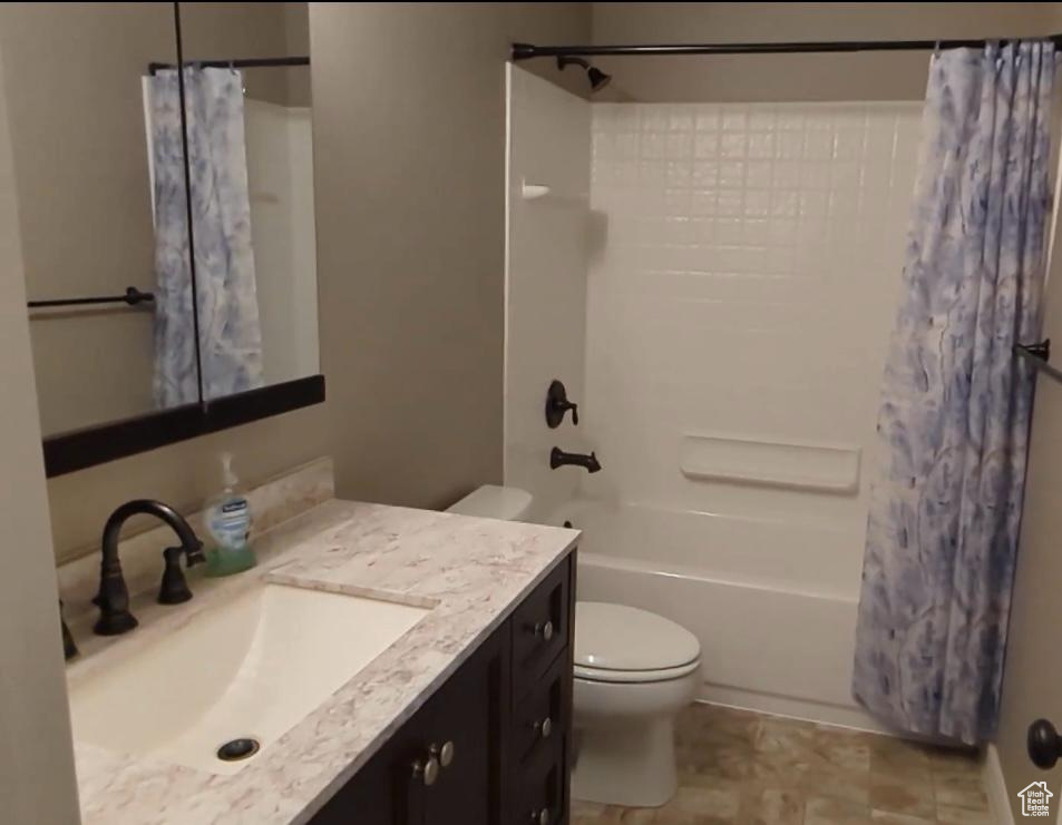 Full bath featuring toilet, shower / tub combo with curtain, and vanity