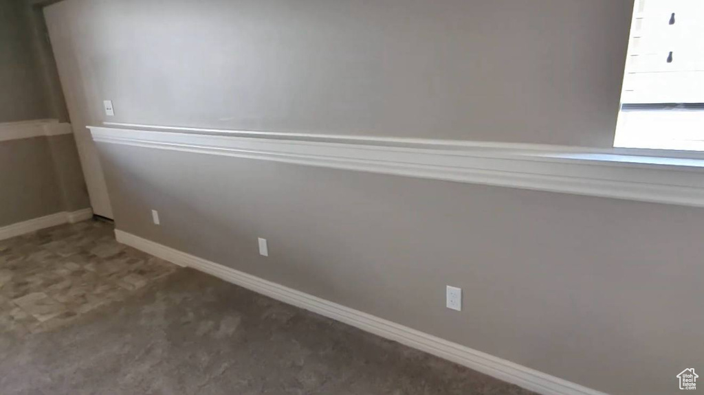 Carpeted empty room featuring baseboards