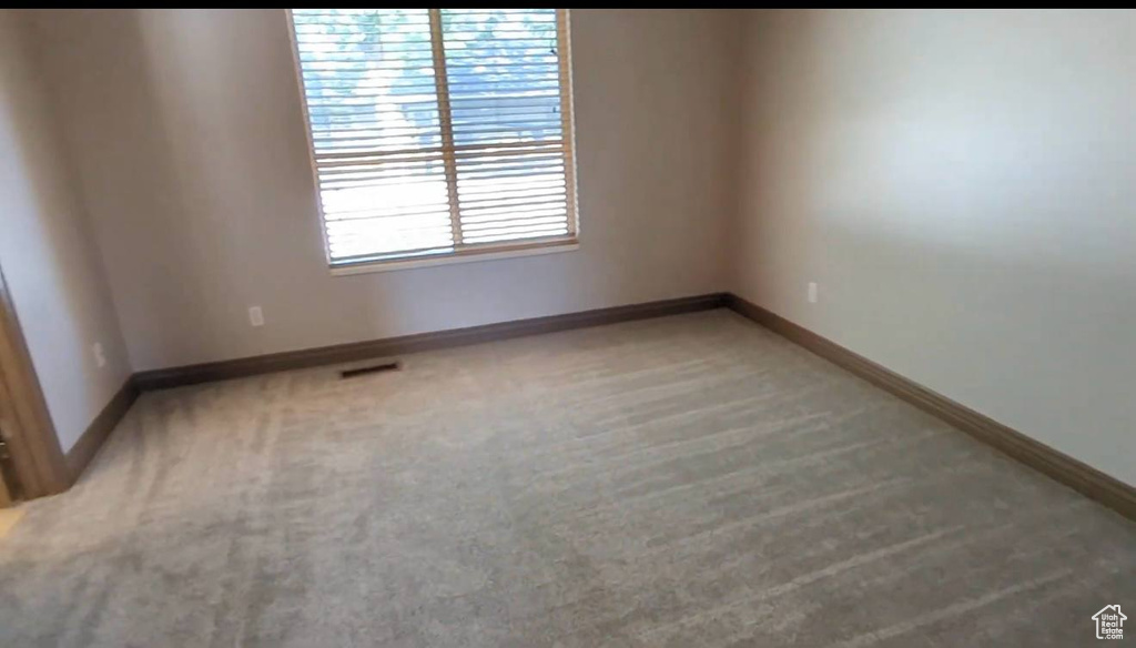 Unfurnished room with light carpet and baseboards