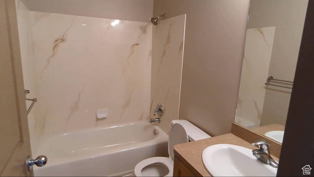 Bathroom featuring toilet, bathtub / shower combination, and vanity