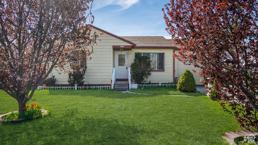 View of front of house with a front lawn, a shingled roof, entry steps, and an attached garage