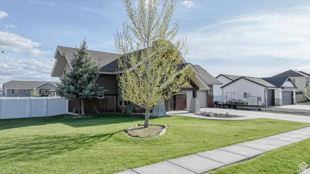 View of front of property with concrete driveway, an attached garage, roof with shingles, and a residential view