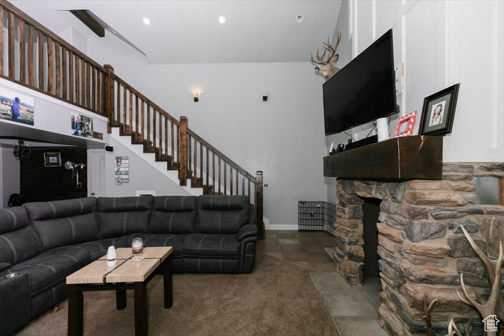 Carpeted living room with recessed lighting and a towering ceiling