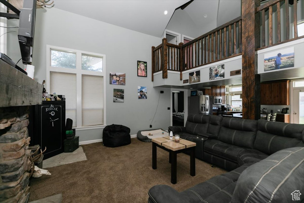 Carpeted living room featuring high vaulted ceiling and baseboards