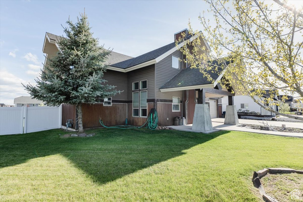 Back of property with roof with shingles and an attached garage