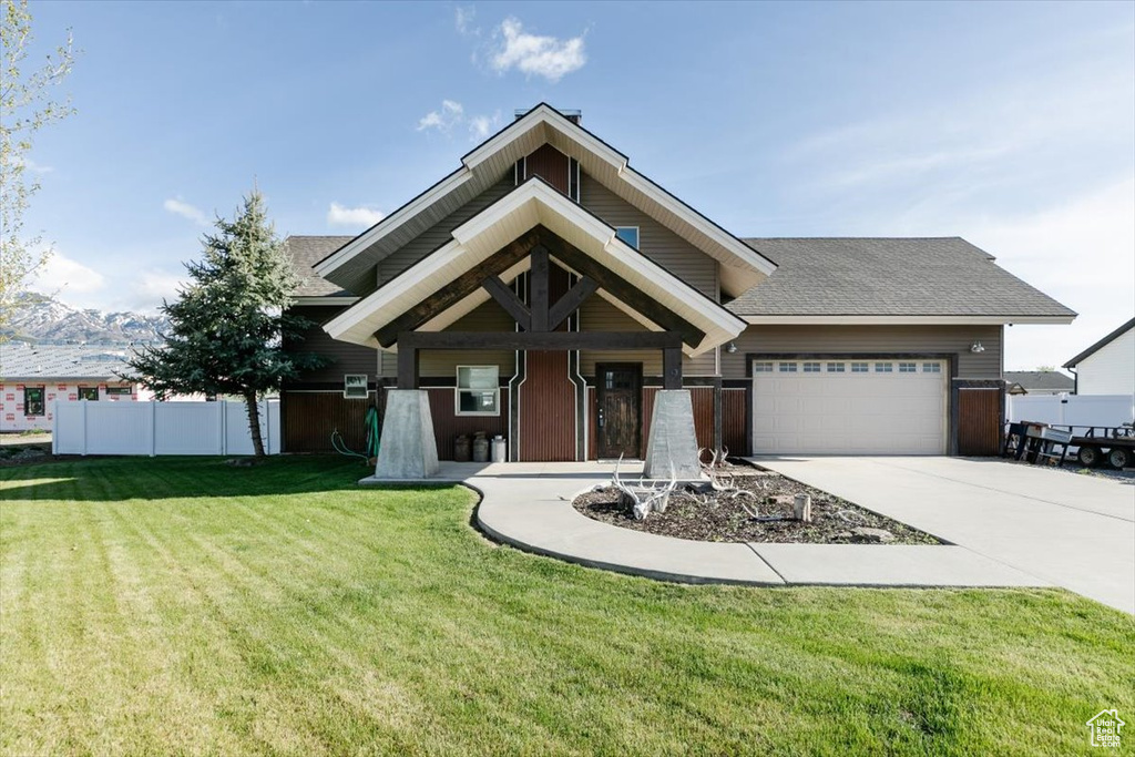 View of front of property featuring an attached garage, driveway, and a shingled roof
