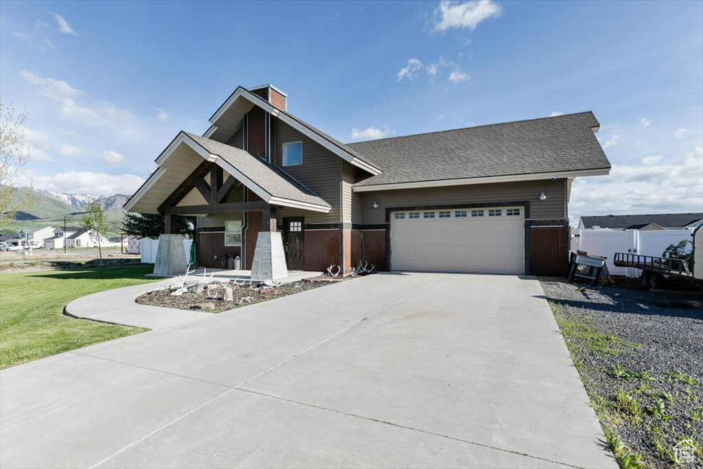 Craftsman-style house with concrete driveway, a chimney, an attached garage, and roof with shingles