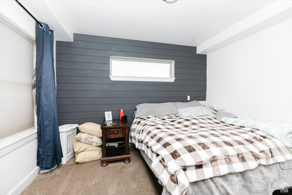 Bedroom featuring carpet and wood walls
