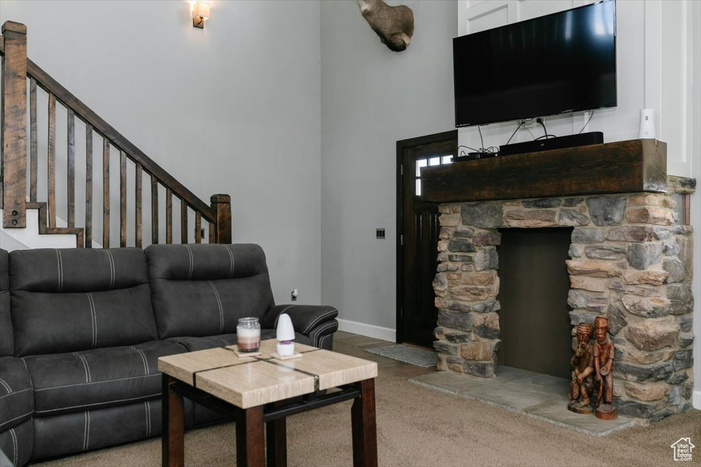 Carpeted living area featuring stairway and a high ceiling