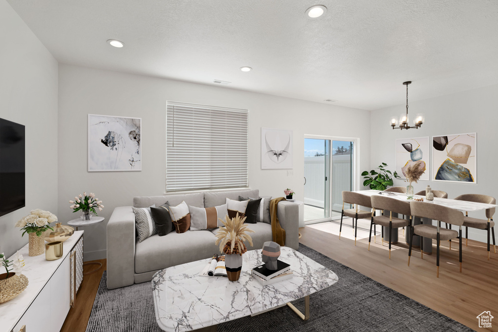 Living area with wood finished floors, a chandelier, and recessed lighting