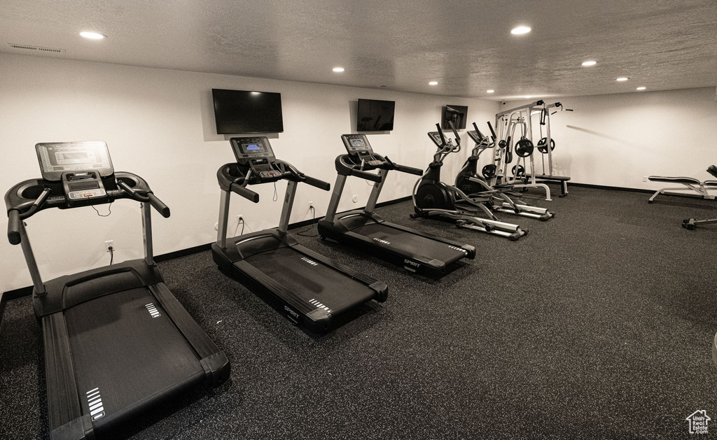 Gym with baseboards, recessed lighting, and a textured ceiling