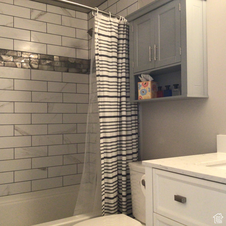 Full bath with shower / bath combination with curtain, toilet, and vanity