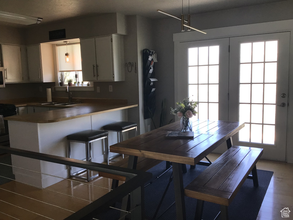Dining space featuring light wood finished floors, a wealth of natural light, and a textured ceiling