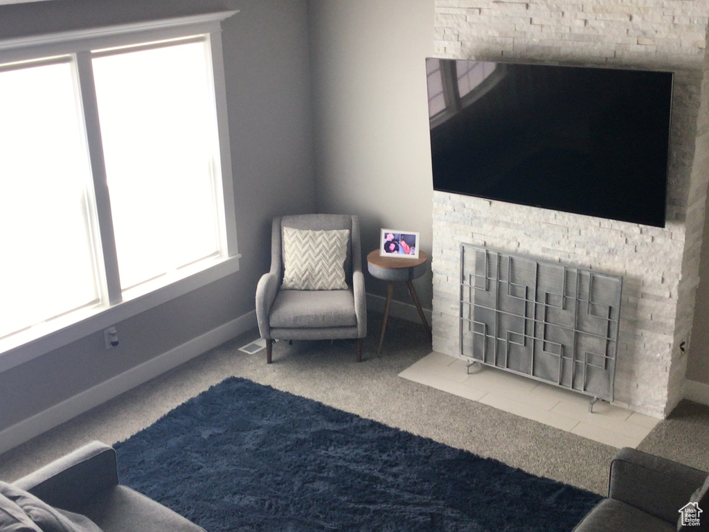 Living area with visible vents, plenty of natural light, baseboards, and carpet