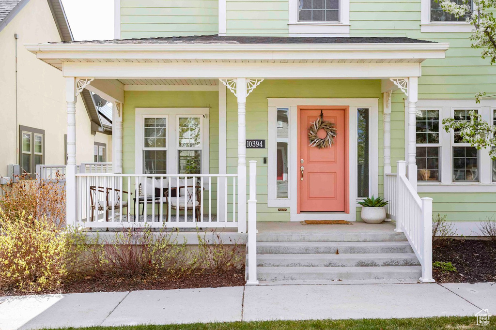 Doorway to property featuring covered porch