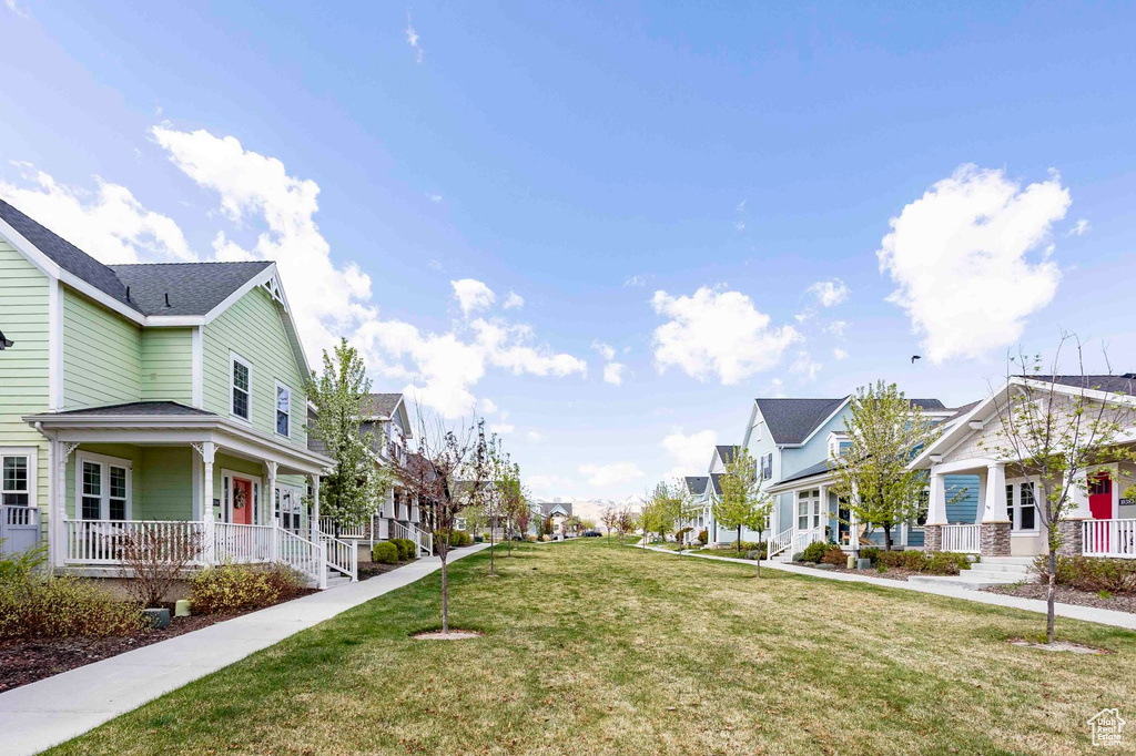 View of home's exterior featuring a yard, a residential view, and covered porch