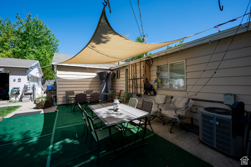 View of patio with an outdoor structure, central AC unit, and outdoor dining area