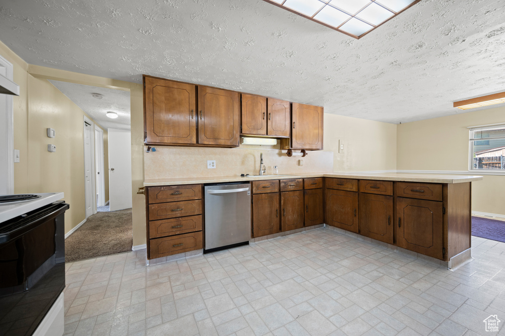 Kitchen featuring dishwasher, light countertops, electric stove, a peninsula, and baseboards