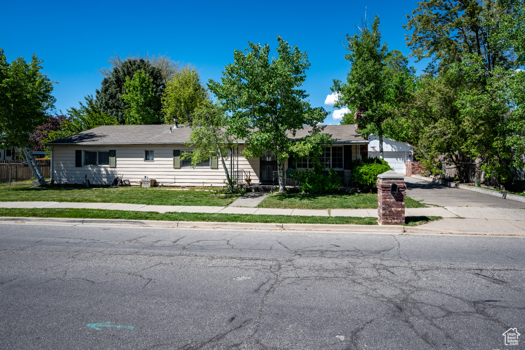 Single story home with fence, driveway, and a front yard