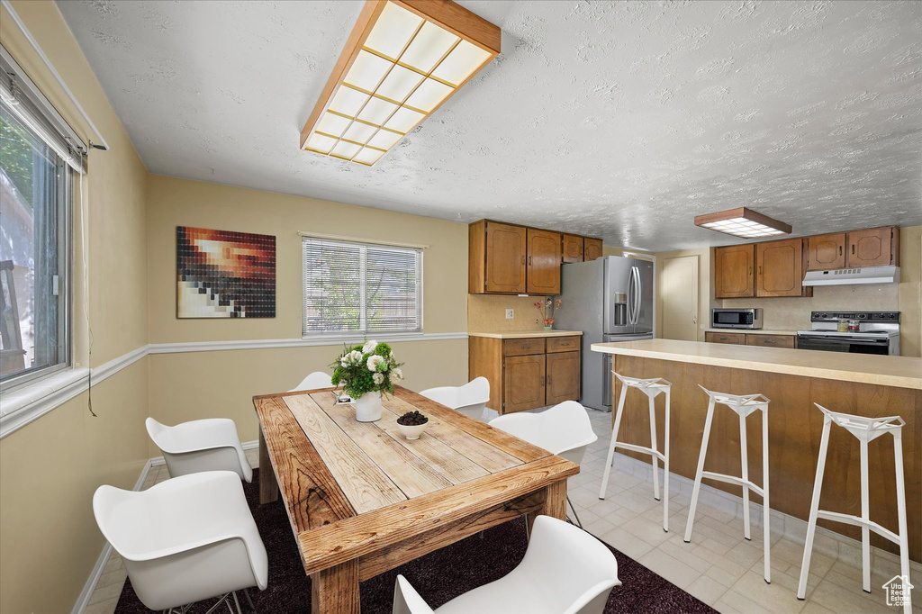 Dining area with a textured ceiling and baseboards