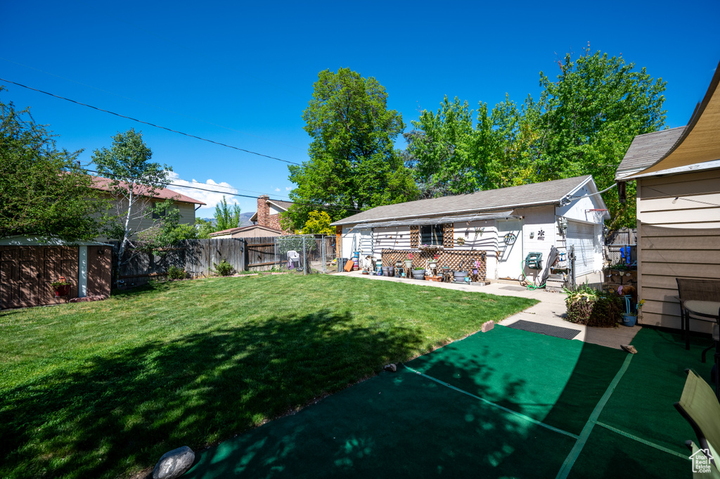 Back of house with a yard and a fenced backyard