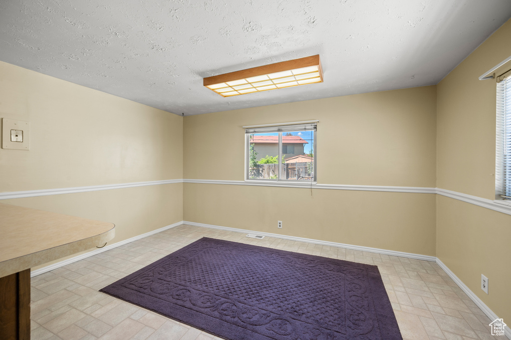 Spare room with baseboards and a textured ceiling