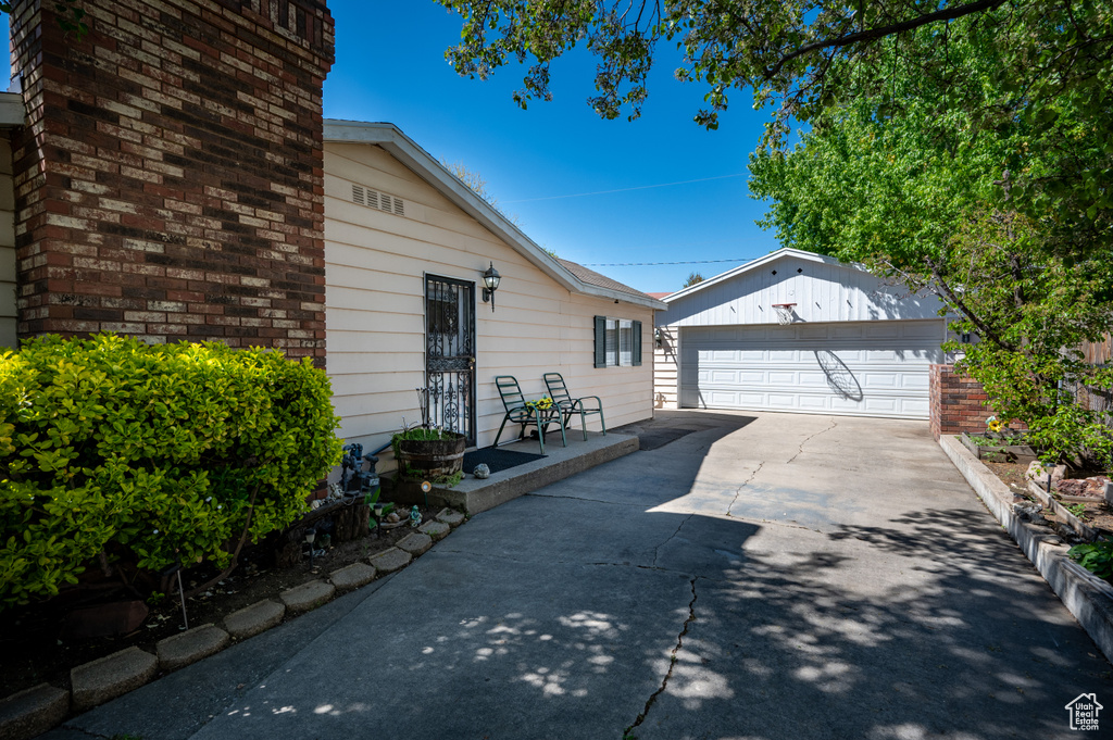 View of side of home with a garage and an outbuilding
