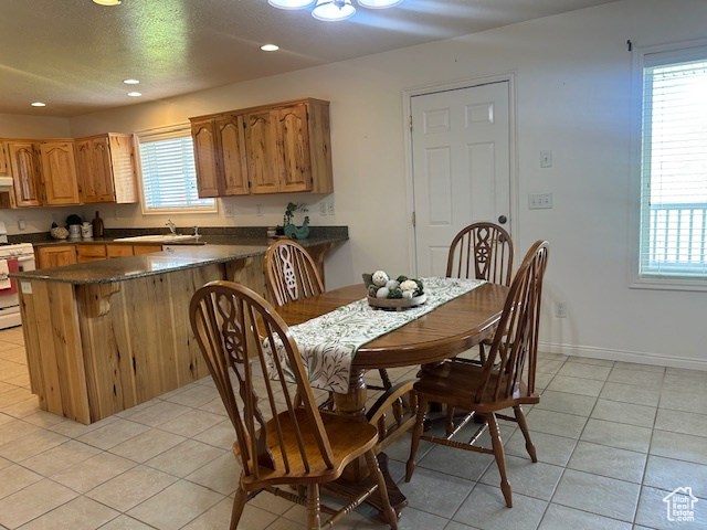 Dining space featuring light tile patterned floors, recessed lighting, and a textured ceiling
