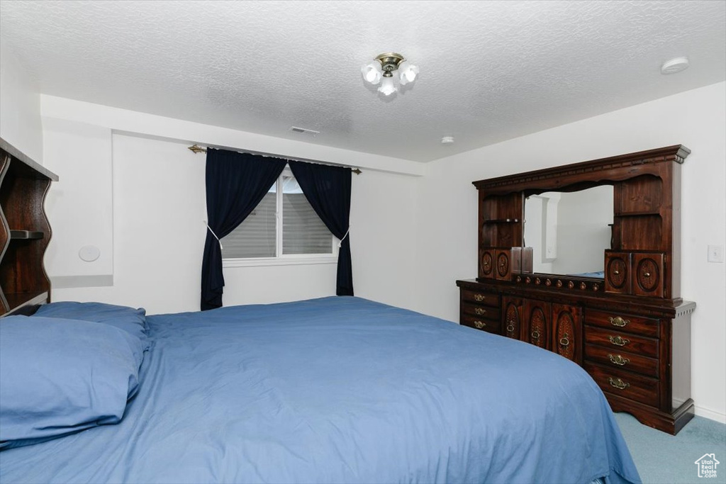 Carpeted bedroom featuring a textured ceiling