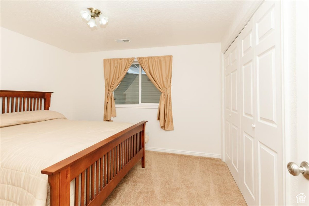 Carpeted bedroom with a closet