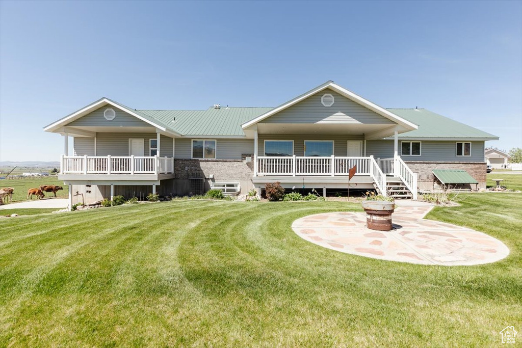 View of front of home with a front lawn and a fire pit