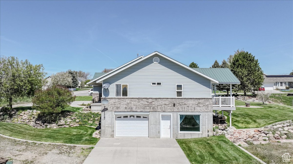 View of home's exterior with a garage, a yard, and driveway