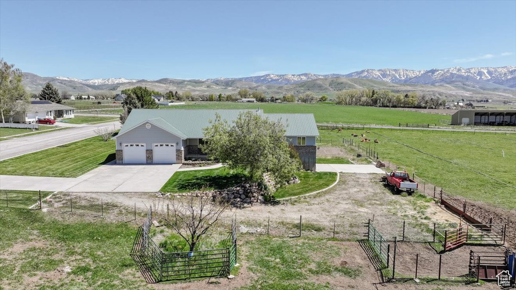 View of front of property with a view of rural / pastoral area, driveway, an attached garage, and a mountain view